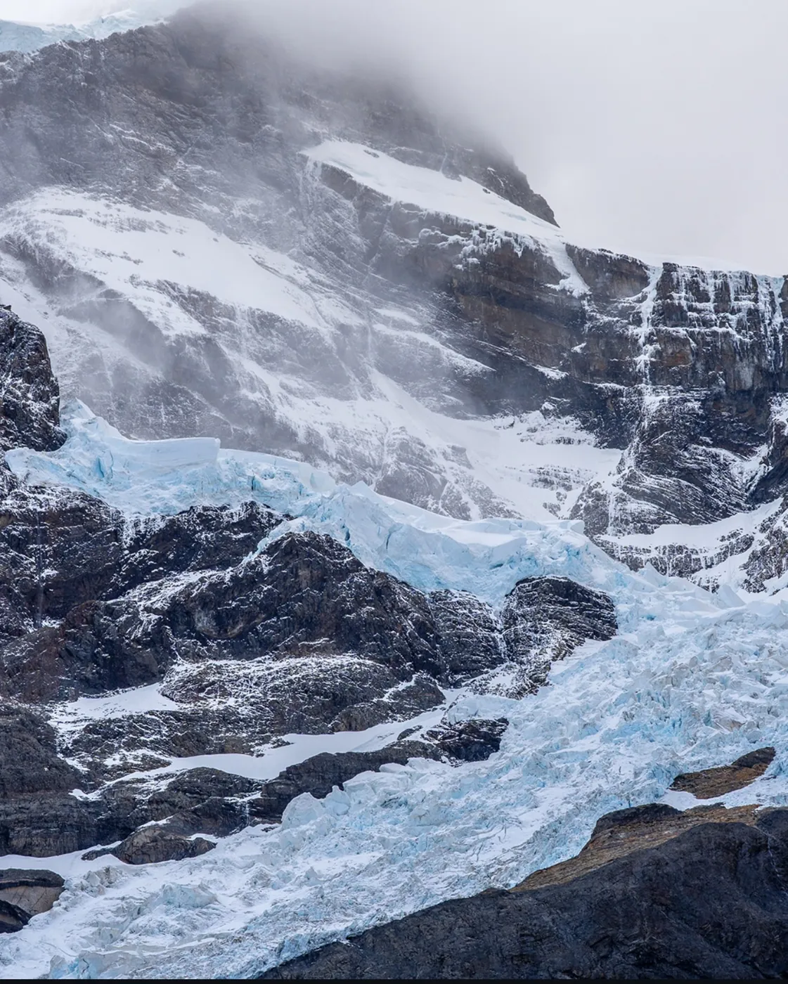 Glaciar y cumbres nevadas entre paredes de roca